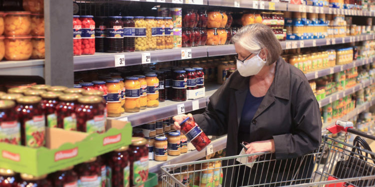 FILE PHOTO: An elderly woman wearing a face mask shops in a supermarket, after the federal state of North Rhine-Westphalia decided to make wearing protective masks obligatory in shops and public transportation to fight the spread of the coronavirus disease (COVID-19), in Bad Honnef near Bonn,  Germany, April 27, 2020. REUTERS/Wolfgang Rattay/File Photo